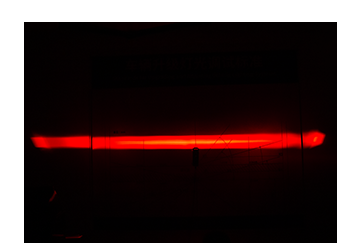 DXZ product projection photograph showing a red line across a dark surface.