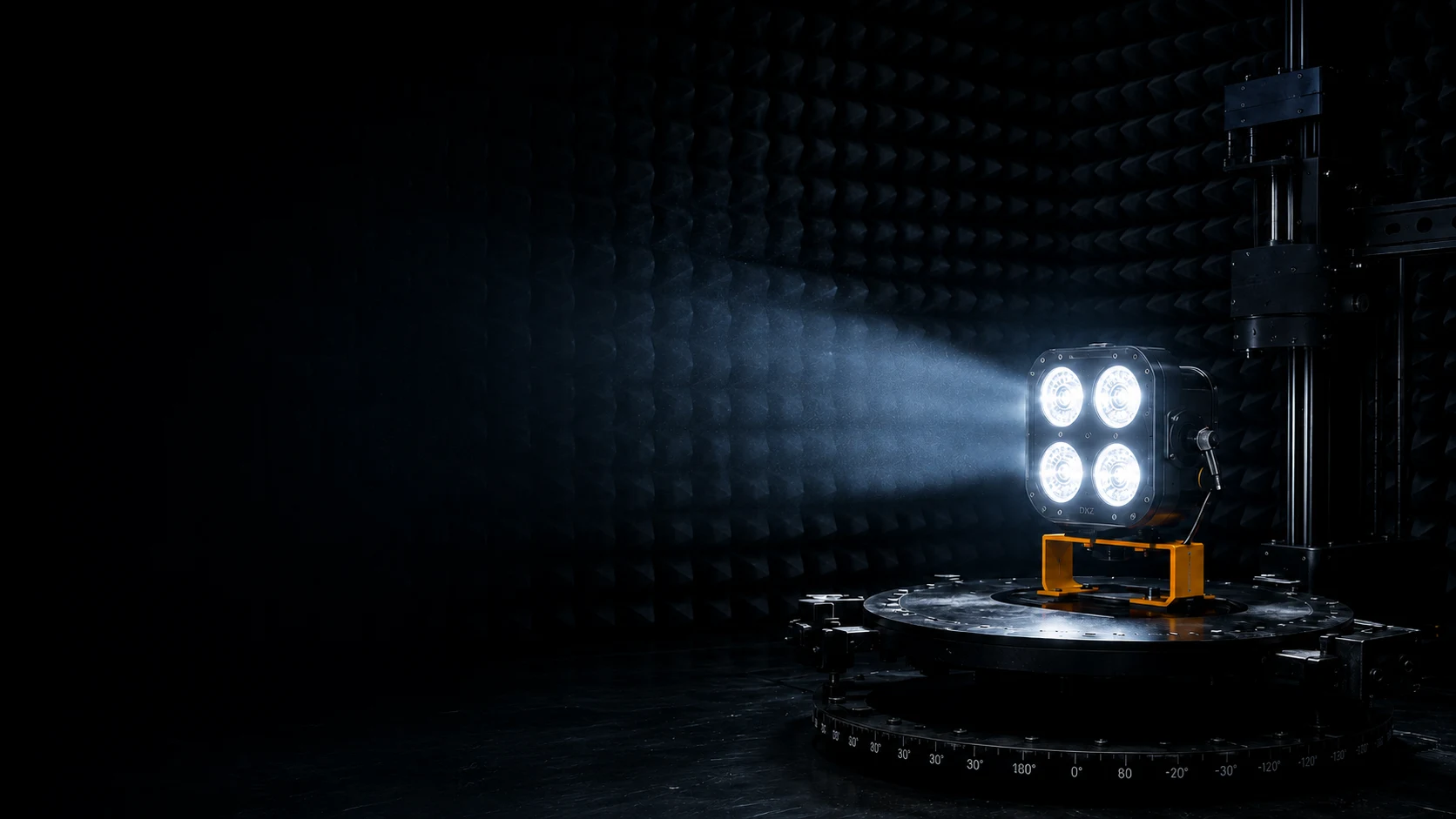 DXZ vehicle lamp under photometric test in a dark room, mounted on a goniophotometer turntable inside anechoic foam-lined walls